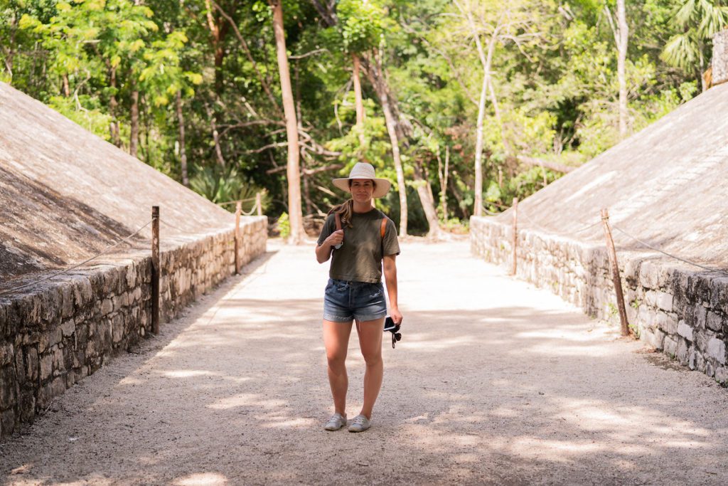 girl standing at coba mayan ruins