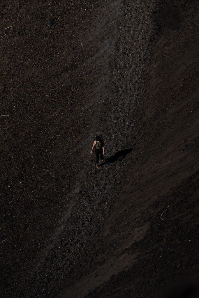 girl hiking down lava rock trail in lassen
