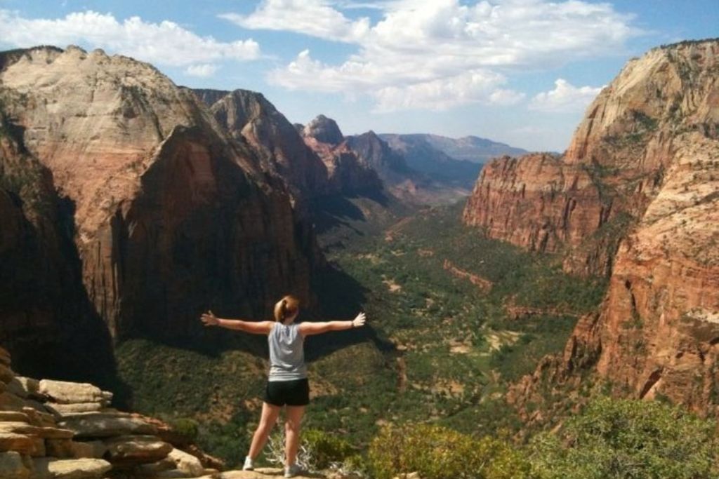 traveler with arms outstretched at the top of angels landing in zion