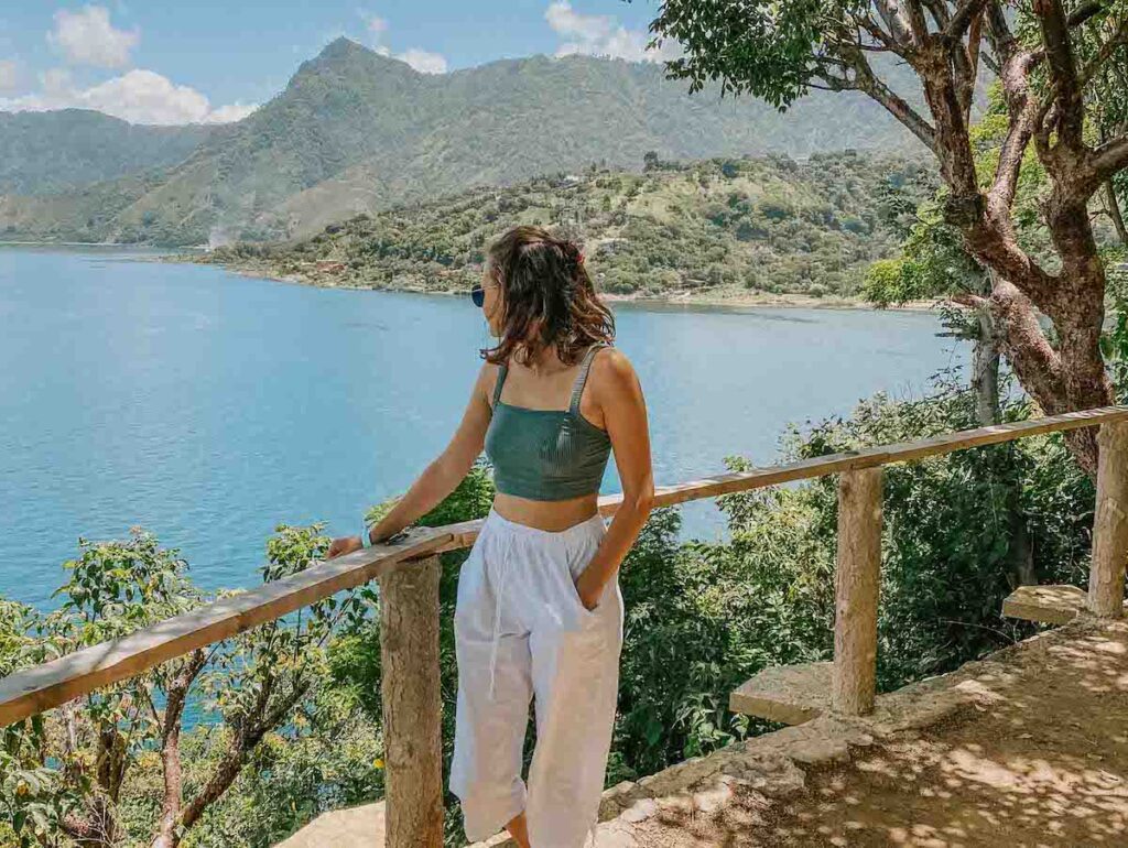 girl standing and looking back at lake atitlan in guatemala